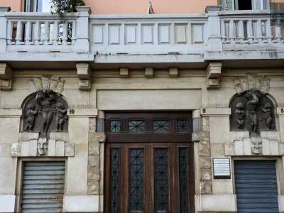 ...presenta un basamento a bugne grezze dove si apre l�ingresso principale impreziosito da due bassorilievi di stampo classico